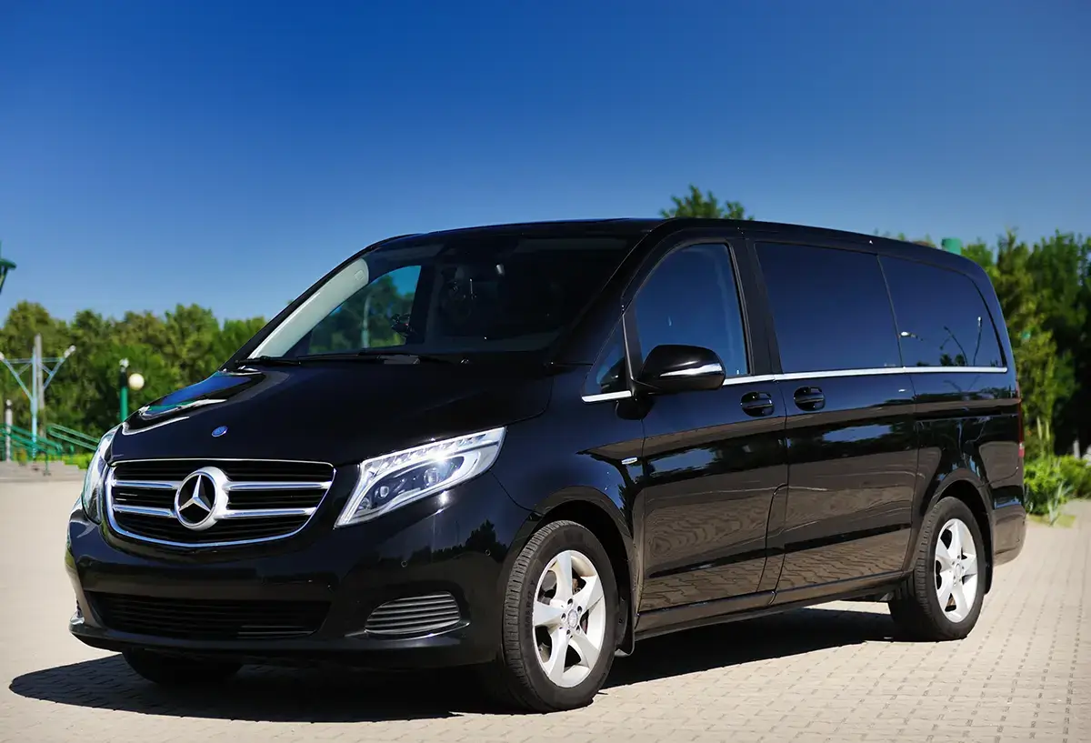 Van Mercedes-Benz Classe V noir, lumineux, garé en extérieur sous un ciel bleu.